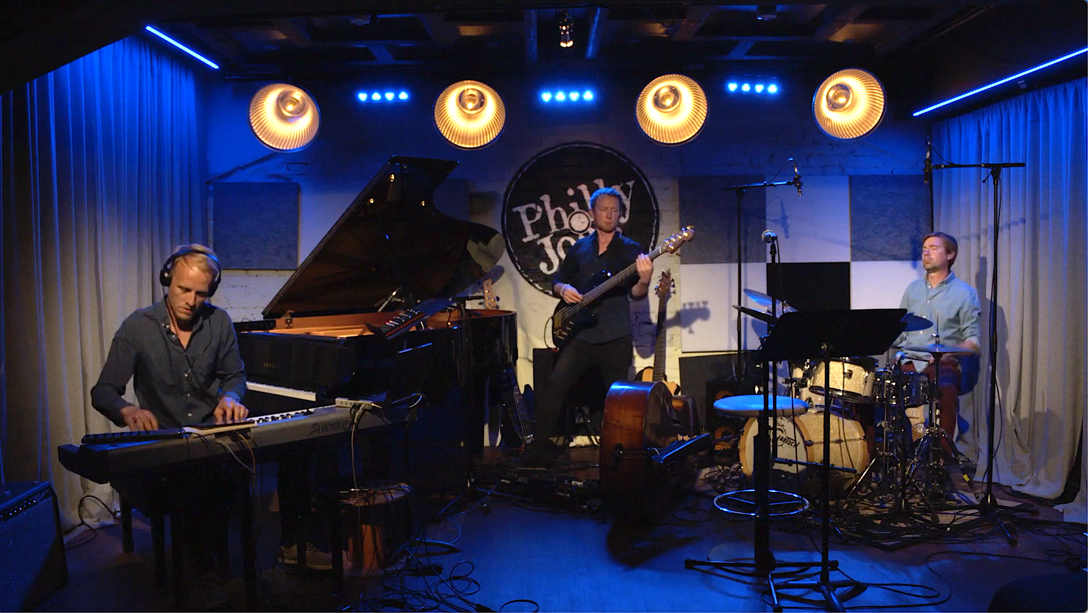 Trio of jazz musicians playing instruments on a stage.